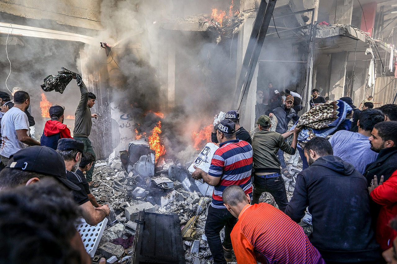 Des Palestiniens tentent d'éteindre un incendie après une frappe aérienne israélienne sur une maison du camp de réfugiés de Shaboura, dans la ville de Rafah, au sud de la bande de Gaza, le 17 novembre 2023. (Abed Rahim Khatib/Flash90)